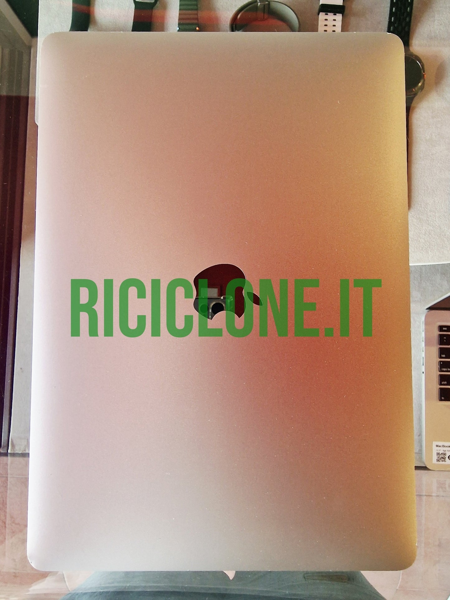 Closed gold Apple MacBook Air lid with reflective logo top-down view